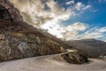 Winding road with multicolored volcanic cliffs to Athinios Port, Santorini Royalty Free Stock Photo