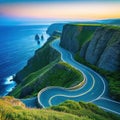 a winding road near the ocean with a view of the ocean in the distance and a cliff on the side of the road on the other side Royalty Free Stock Photo