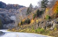 Winding road in the rocky mountains of Vermont with autumn yellowed maple trees along the road and on the mountains Royalty Free Stock Photo