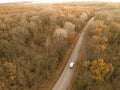 Winding rual road inside colorful autumn forest with car Royalty Free Stock Photo