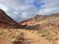 the road is narrow and leads through a canyon with colorful mountain in the background