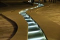 A winding stream with lights in a stone channel.Element of urban decor.
