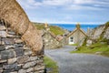Winding street with several restored thatched cottages in Garenin or Gearrannan Blackhouse Village Royalty Free Stock Photo