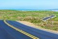 Winding two lane road on scenic Pacific Ocean coastline on a clear sunny day