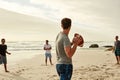 Winding up for the perfect toss. a group of happy young friends playing with a ball on the beach. Royalty Free Stock Photo