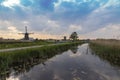 A windmill by a canal in Kinderdijk Holland is reflected in the water Royalty Free Stock Photo