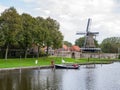 Windmill de Kaai and canal with sailboat in city of Sloten, Sleat, Friesland, Netherlands Royalty Free Stock Photo