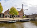 Windmill de Kaai, Heerenwal with houses and canal in Sloten, Sleat, Friesland, Netherlands Royalty Free Stock Photo