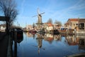 Windmill de Roode Leeuw with reflection in the Turfsingel in Gouda with sails on it.