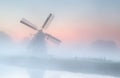 Windmill in dense fog at summer sunrise Royalty Free Stock Photo