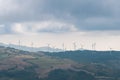 Windmill electricity turbines on a hill in Italian countryside