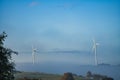 Windmill in foggy landscape. Renewable energy for environmentally conscious future