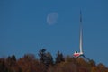 Windmill on a forest hilltop and the moon with blue sky Royalty Free Stock Photo