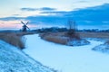 Windmill and frozen river in snow