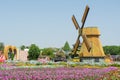 Windmill in the garden near flower field