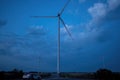 Windmill generates renewable energy with propeller at dusk
