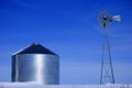 Windmill and Grain Silos in Winter Snow on Farm for Agricultural Farming Royalty Free Stock Photo