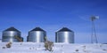 Windmill and Grain Silos in Winter Snow on Farm for Agricultural Farming Royalty Free Stock Photo