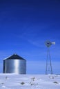 Windmill and Grain Silos in Winter Snow on Farm for Agricultural Farming Royalty Free Stock Photo