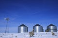 Windmill and Grain Silos in Winter Snow on Farm for Agricultural Farming Royalty Free Stock Photo