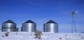 Windmill and Grain Silos in Winter Snow on Farm for Agricultural Farming Royalty Free Stock Photo