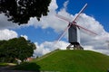 Windmill on a grass hill and trees Royalty Free Stock Photo