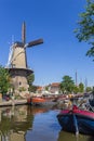 Windmill and historic ships at the canal in Gouda Royalty Free Stock Photo
