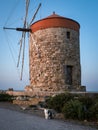 Windmill of Mandraki, Rhodes town, Greece, at sunset. A cat sitting in front of the mill.