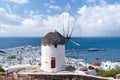 Windmill on mountain by sea in Mykonos, Greece. Windmill on seascape on cloudy sky. White building with sail and straw Royalty Free Stock Photo