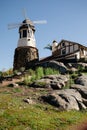 Windmill with old rock castle. red tile roof and string lights. Modern windmill. Country side on a bright summer day