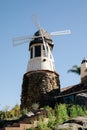 Windmill with old rock castle. red tile roof and string lights. Modern windmill. Country side on a bright summer day