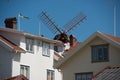 Windmill over rooftops Royalty Free Stock Photo