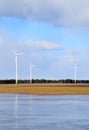 Windmill park in Latvia - view from ploughland with frozen waters.