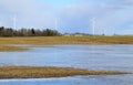 Windmill park in Latvia - view from ploughland with frozen waters.