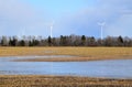 Windmill park in Latvia - view from ploughland with frozen waters.