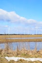 Windmill park in Latvia - view from ploughland with frozen waters.