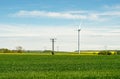 Windmill and power pylon on an agricultural field