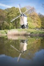 Dutch post windmill with reflection in the water