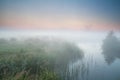 Windmill and river in morning fog Royalty Free Stock Photo