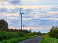 Windmill on rural road in the sunset. Wind turbines farm.