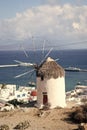 Windmill by sea in Mykonos, Greece. Windmill on mountain landscape cloudy sky. Whitewashed building with sail and straw Royalty Free Stock Photo