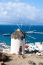 Windmill by sea in Mykonos, Greece. Windmill on mountain landscape cloudy sky. Whitewashed building with sail and straw Royalty Free Stock Photo