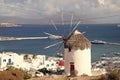 Windmill on seascape in Mykonos, Greece. Windmill on mountain by sea on sky. Whitewashed building with sail and straw