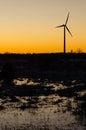 Windmill silhouette in a plain landscape with water reflections