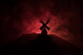 Windmills is silhouette against the night sky. Night decor with old windmill on hill with horror toned foggy background with light Royalty Free Stock Photo