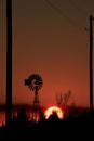 Windmill silhouette at Sunset with a blazing red sky out in the country Royalty Free Stock Photo