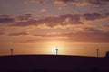 Windmill silhouettes on a hill