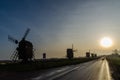 Windmill silhouettes by roadside