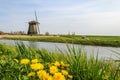 Windmill stands on a grassland near a canal of Netherlands