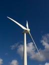 Windmill in the sun against blue sky with soft clouds